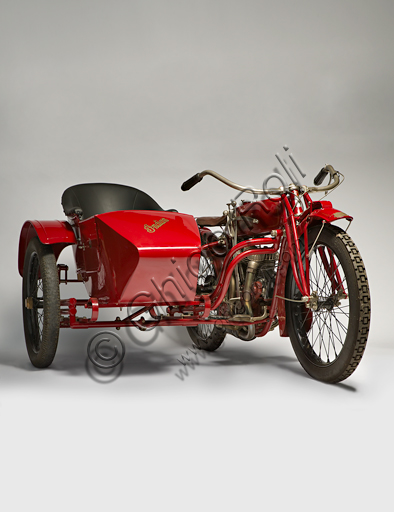 Vintage motorcycle Indian Powerplus 1000 Side.Brand: Indianmodel: Powerplus 1000 Sidecountry: U.S.A. - Springfieldyear: 1919conditions: restoreddisplacement: 61 ci (987.7 cc. bore and stroke 79.3 x 100)engine: 42 ° V twin cylinder with side valvesgearbox: three-speed with hand controlThe Indian Motorcycle Manufacturing Company is the oldest U.S. motorcycle factory. Founded by George M. Hendee and Carl Oscar Headstrom in 1901, two years before Harley Davidson, it was always on the cutting edge of technology. In 1911 he built four-valve racing engines, in '12 he introduced the rear suspension, in '14 he also provided the electric starter as an option. With the first twin-cylinder Erwin Baker "Cannonball" sets many records on long distance races. In 1914 he went from San Diego to New York, beating previous records in "only" 11 days and twelve hours.In 1916, the Powerplus twin-cylinder of the model shown here came out. It was a silent, elastic and powerful V-twin engine that reaches 60 mph (96 km / h) and had a great success both as an engine for tourist use and as a base for racing bikes.