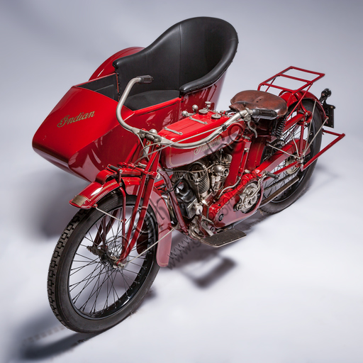 Moto d'epoca Indian Powerplus 1000 Side.Marca: Indianmodello: Powerplus 1000 Sidenazione: U.S.A. - Springfieldanno: 1919condizioni: restauratacilindrata: 61 ci (987,7 cc.  alesaggio e corsa 79,3 x 100)                                                               motore: bicilindrico a V di 42° a valvole lateralicambio: a tre rapporti con comando a manoLa Indian Motorcycle Manufacturing Company è la più antica fabbrica statunitense di moto. Fondata da George M. Hendee e Carl Oscar Headstrom nel 1901, due anni prima della Harley Davidson, fu sempre all'avanguardia tecnologica. Nel 1911 costruisce motori da corsa a quattro valvole, nel '12 introduce la sospensione posteriore, nel '14 fornisce anche l'avviamento elettrico come optional. Con il primo bicilindrico Erwin Baker "Cannonball" firma numerosi record su gare di lunga distanza. Nel 1914 va da San Diego a New York battendo i record precedenti in "soli" 11 giorni e dodici ore.Nel 1916 esce il bicilindrico Powerplus dell'esemplare qui riprodotto, un motore bicilindrico a V silenzioso, elastico e potente che consente di raggiungere le 60 mph (96 km/h) e riscuote un grande successo sia come motore per uso turistico che come base per le moto da corsa.  