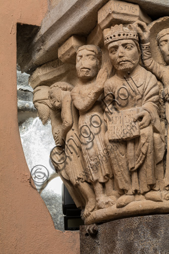 Modena, Ghirlandina Tower, Torresani Hall: the "Capital of the Judge" or "of the Upright Judge and of the Corrupt Judge", work by Campionesi masters, XII - XIII century.There are three carved scenes. Detail of two scenes: the good judge crowned by an angel and a barefoot man with his hand clasped in the act of supplication. The inscription informs us that a crooked judge corrupted by money will give a judgment not in accordance with his conviction.