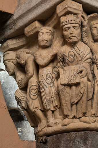 Modena, Ghirlandina Tower, Torresani Hall: the "Capital of the Judge" or "of the Upright Judge and of the Corrupt Judge", work by Campionesi masters, XII - XIII century.There are three carved scenes. Detail of  one which represents the good judge crowned by an angel. In the other scene a judge is approached by a man carrying a bag and a barefoot man, pleading with his hands clasped.The inscription informs us that a crooked judge corrupted by money will give a judgment not in accordance with his conviction.