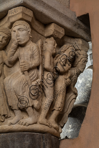 Modena, Ghirlandina Tower, Torresani Hall: the "Capital of the Judge" or "of the Upright Judge and of the Corrupt Judge", work by Campionesi masters, XII - XIII century.There are three carved scenes. Detail of a scene which represents  the corruption of the bad judge is represented. The crooked judge is depicted with a chain around his neck held by Lucifer.The inscription informs us that a crooked judge corrupted by money will give a judgment not in accordance with his conviction.