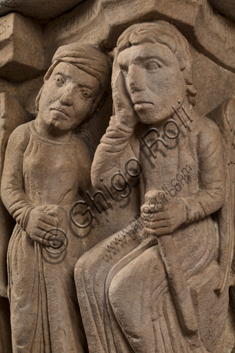 Modena, Ghirlandina Tower, Torresani Hall: the "Capital of the Judge" or "of the Upright Judge and of the Corrupt Judge", work by Campionesi masters, XII - XIII century.There are three carved scenes. Detail of  an angel, a man in the act of supplication and Lucifer. The inscription informs us that a crooked judge corrupted by money will give a judgment not in accordance with his conviction.