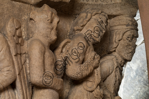 Modena, Ghirlandina Tower, Torresani Hall: the "Capital of the Judge" or "of the Upright Judge and of the Corrupt Judge", work by Campionesi masters, XII - XIII century.There are three carved scenes. Detail of a scene which represents  the corruption of the bad judge is represented. The crooked judge is depicted with a chain around his neck held by Lucifer.The inscription informs us that a crooked judge corrupted by money will give a judgment not in accordance with his conviction.