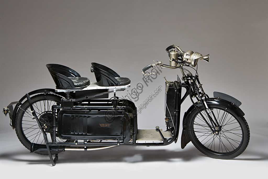 Moto d'epoca Reynolds Runabout. Scooter.Marca: Jackson Car Mfg. Co. (poi A.W. Wall Ltd.)modello: Reynolds Runaboutnazione: Regno Unito - Birminghamanno: 1921condizioni: restauratocilindrata: 269 ccmotore: Wall-Liberty, a due tempicambio: Moss, a due rapporti" A car on two wheels", un'auto su due ruote, recita lo slogan con cui venne conosciuto questo scooter che pur essendo tra i migliori e i più apprezzati per la comodità, non ebbe grande diffusione a causa del prezzo elevato e le notevoli dimensioni. Il motore sotto la sella era protetto e nascosto da pannelli in lamiera, i serbatoi di olio e benzina erano applicati al montante verticale dello scudo paragambe.