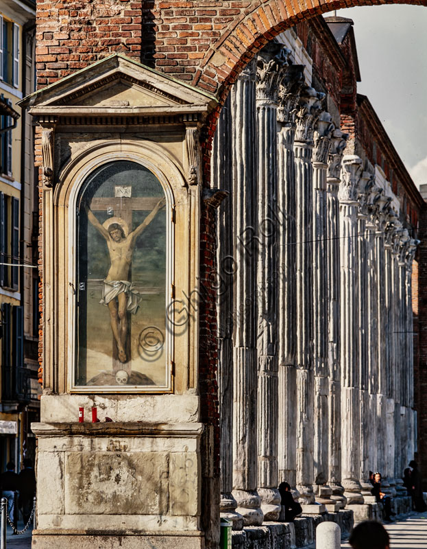 Chiesa di S. Lorenzo Maggiore o alle Colonne:  veduta delle 16 colonne romane corinzie,  II-III  sec. in primo piano “crocifissione”, dipinto all’estremità destra del colonnato.