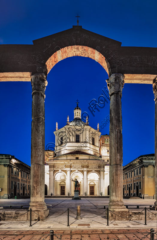 Chiesa di S. Lorenzo Maggiore o alle Colonne: veduta serale della facciata e del sagrato con al centro la statua bronzea di Costantino imperatore. In primo piano le colonne romane.