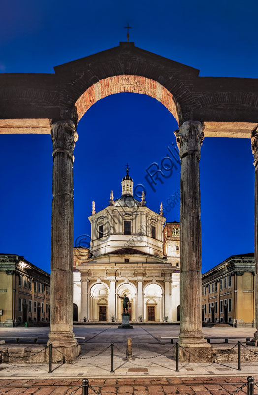  Church of S. Lorenzo Maggiore or alle Colonne: night view of the facade and the churchyard with the bronze statue of Emperor Constantine in the centre. In the foreground, some Roman columns.