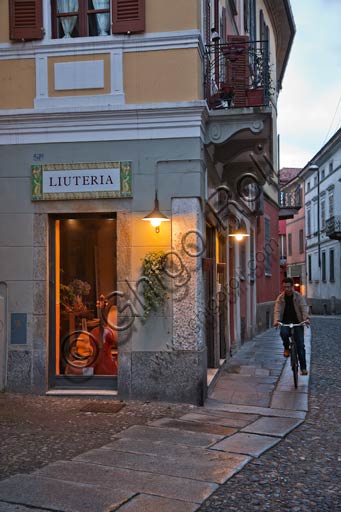 Cremona, bottega di liutaio e ragazzo in bicicletta.