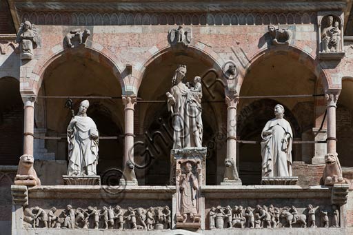  Cremona, Duomo (Cathedral), facade, loggia over the Portal: Madonna with Infant Jesus between Saint Omobono e Imerio Bishop; marble frieze representing the months (1120-1230). The statue under the Virgin Mary represents Bishop Sicardo.