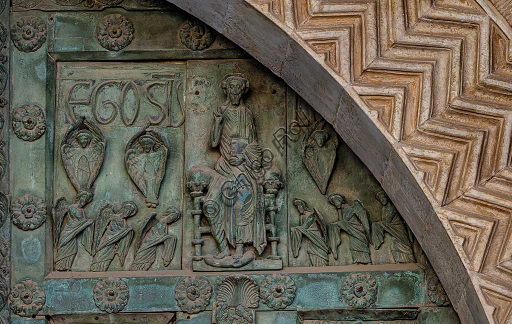 Duomo di Monreale, Porta di Bonanno Pisano (1185-6): formella bronzea con "Cristo in trono" (scena dal Nuovo Testamento).La porta è firmata: "Bonanno civis pisanus". Iconograficamente nei cinque ordini inferiori vi sono scene del Vecchio Testamento, sette dedicate alla storia di Adamo ed Eva, e altre sei ad altrettante coppie di profeti mentre nei cinque superiori scene del Nuovo, al sommo Cristo e Maria nella gloria del Paradiso.