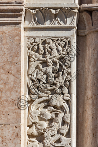  Foligno, Cathedral of  St. Feliciano, the façade:  the entrance door. Detail of the frieze of  the portal. The central portal, work of the masters Rodolfo and Binello, shows a solar disk in the lunette, in which there is the inscription with the date 1201, the year of completion of the facade; in the inner façade of the jambs there are then the reliefs with the Emperor Otto IV of Brunswick and Pope Innocent III, while the inner circle of the arch is decorated by the symbols of the evangelists and the Signs of the zodiac; in the outer circle a band of cosmatesque mosaics. The carved wooden portal was made in 1620.