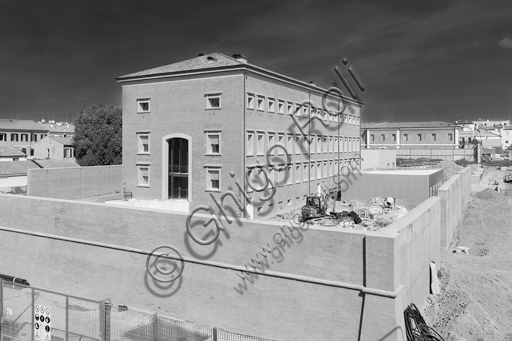  MEIS, National Museum of Italian Judaism and the Shoah in the town of Ferrara: detail of the façade and the surrounding wall flanked by a tree.The MEIS was realised in a building in via Piangipane which is part of the complex consisting of three blocks, enclosed by a double wall. The Museum is therefore the result of a work of conversion of the judicial prison in via Piangipane which was built between 1908 and 1912 based on a design by the engineers Bertotti and Facchini of the Civil Engineer Office. During the twenty years of fascism it became a place of detention for many anti-fascists. After the fall of the regime, on July 30,1943, 88 politic