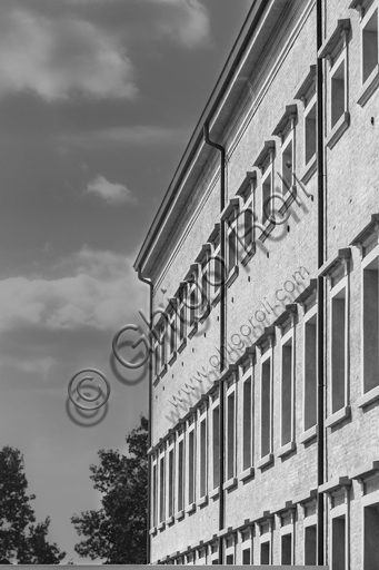  MEIS, National Museum of Italian Judaism and the Shoah in the town of Ferrara: detail of the façade and the surrounding wall flanked by a tree.The MEIS was realised in a building in via Piangipane which is part of the complex consisting of three blocks, enclosed by a double wall. The Museum is therefore the result of a work of conversion of the judicial prison in via Piangipane which was built between 1908 and 1912 based on a design by the engineers Bertotti and Facchini of the Civil Engineer Office. During the twenty years of fascism it became a place of detention for many anti-fascists. After the fall of the regime, on July 30,1943, 88 politic