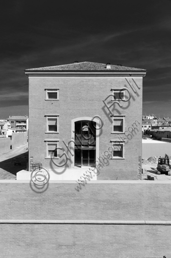  MEIS, National Museum of Italian Judaism and the Shoah in the town of Ferrara: detail of the façade and the surrounding wall flanked by a tree.The MEIS was realised in a building in via Piangipane which is part of the complex consisting of three blocks, enclosed by a double wall. The Museum is therefore the result of a work of conversion of the judicial prison in via Piangipane which was built between 1908 and 1912 based on a design by the engineers Bertotti and Facchini of the Civil Engineer Office. During the twenty years of fascism it became a place of detention for many anti-fascists. After the fall of the regime, on July 30,1943, 88 politic