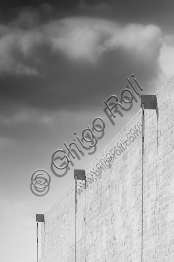  MEIS, National Museum of Italian Judaism and the Shoah in the town of Ferrara: detail of the façade and the surrounding wall flanked by a tree.The MEIS was realised in a building in via Piangipane which is part of the complex consisting of three blocks, enclosed by a double wall. The Museum is therefore the result of a work of conversion of the judicial prison in via Piangipane which was built between 1908 and 1912 based on a design by the engineers Bertotti and Facchini of the Civil Engineer Office. During the twenty years of fascism it became a place of detention for many anti-fascists. After the fall of the regime, on July 30,1943, 88 politic