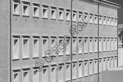  MEIS, National Museum of Italian Judaism and the Shoah in the town of Ferrara: detail of the façade and the surrounding wall flanked by a tree.The MEIS was realised in a building in via Piangipane which is part of the complex consisting of three blocks, enclosed by a double wall. The Museum is therefore the result of a work of conversion of the judicial prison in via Piangipane which was built between 1908 and 1912 based on a design by the engineers Bertotti and Facchini of the Civil Engineer Office. During the twenty years of fascism it became a place of detention for many anti-fascists. After the fall of the regime, on July 30,1943, 88 politic