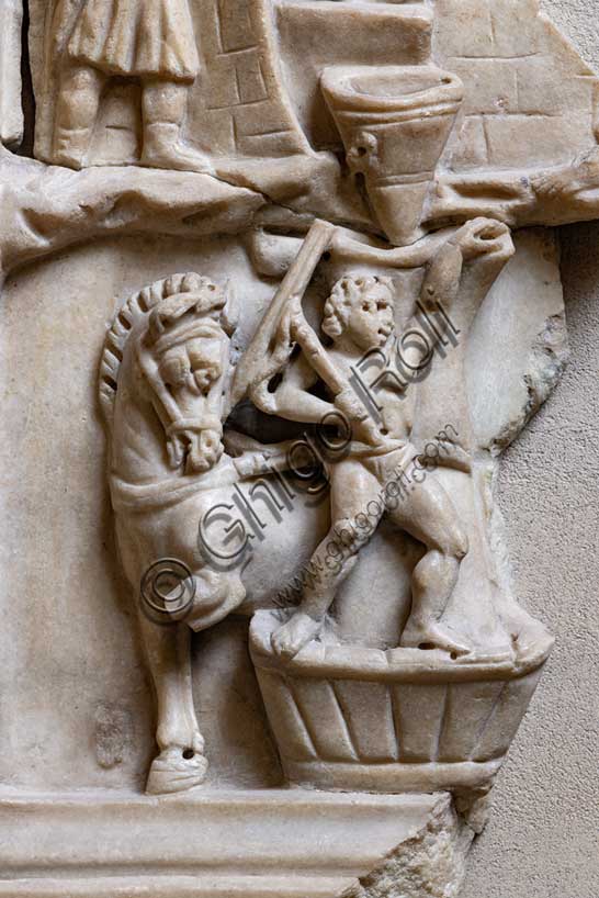 Museo Civico Archeologico di Bologna:rilievo con scena di pistrinum (panificio); rilievo frammentario, proveniente dalla collezione Marsili. Vi sono raffigurate le attività svolte in un panificio.Particolare della macinatura del grano con mola a trazione animale. Inv ROM 1872