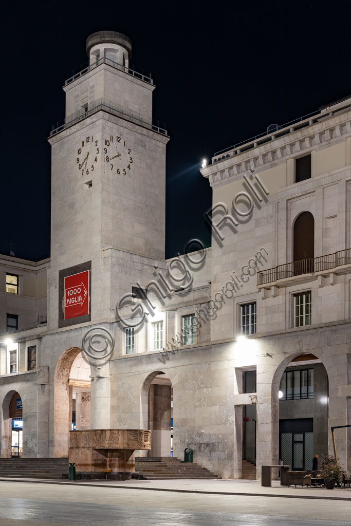 Brescia: veduta serale di piazza della Vittoria (piazza costruita tra il 1927 e il 1932) su progetto dell'architetto e urbanista Marcello Piacentini.  Particolare della Torre della Rivoluzione e dell'Arengario, pulpito in pietra porfirica rossa di Tolmezzo ornato di bassorilievi che rappresentano scene della storia di Brescia, opera di Antonio Maraini.