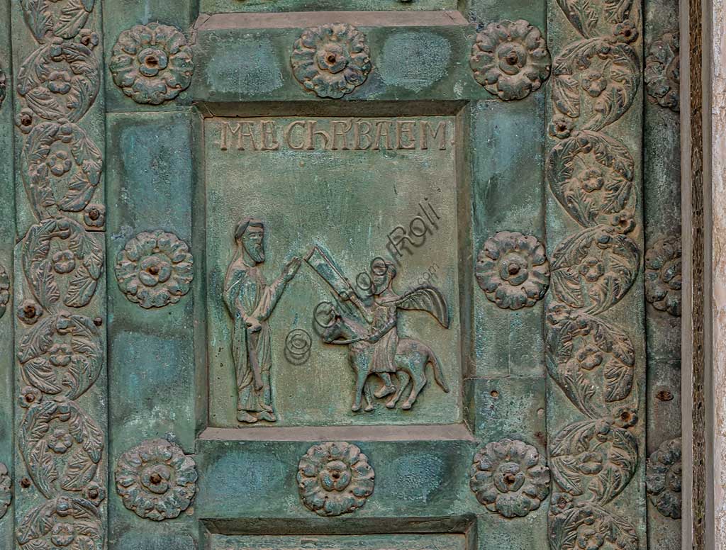 Duomo di Monreale, Porta di Bonanno Pisano (1185-6): formella bronzea con "Due profeti: Malachia e ..." (scena dall'Antico Testamento).La porta è firmata: "Bonanno civis pisanus". Iconograficamente nei cinque ordini inferiori vi sono scene del Vecchio Testamento, sette dedicate alla storia di Adamo ed Eva, e altre sei ad altrettante coppie di profeti mentre nei cinque superiori scene del Nuovo, al sommo Cristo e Maria nella gloria del Paradiso.