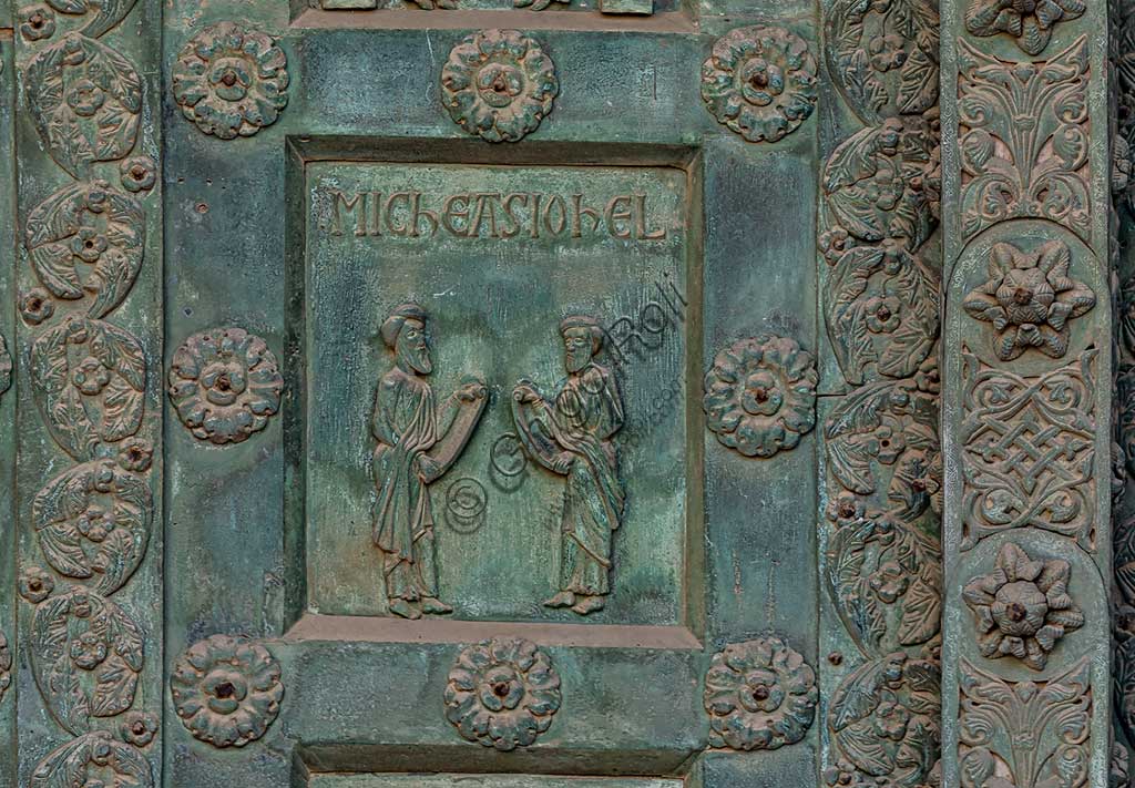 Duomo di Monreale, Porta di Bonanno Pisano (1185-6): formella bronzea con "Due profeti: Michea e Gioele." (scena dall'Antico Testamento).La porta è firmata: "Bonanno civis pisanus". Iconograficamente nei cinque ordini inferiori vi sono scene del Vecchio Testamento, sette dedicate alla storia di Adamo ed Eva, e altre sei ad altrettante coppie di profeti mentre nei cinque superiori scene del Nuovo, al sommo Cristo e Maria nella gloria del Paradiso.