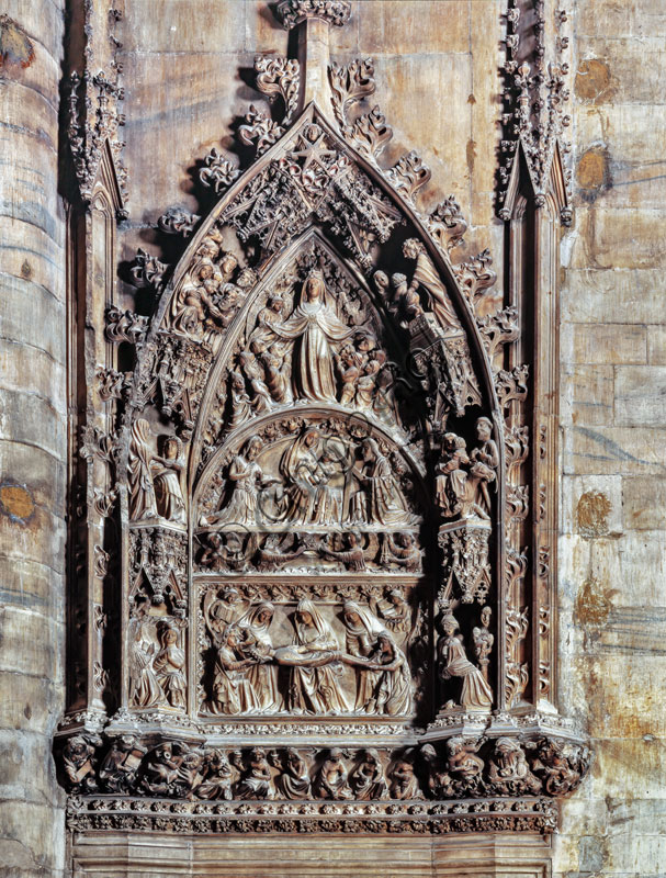  Duomo (the Cathedral): portal of the South sacristy, end XIV century. The scenes depicted in this frame are by Hans von Ernach and other Rhenish artists. Above the frieze of the base with the Mad Virgins and the Wise Virgins, the Deposition, the Madonna of the Milk, the Assumption, flanked by episodes from the life of Jesus.