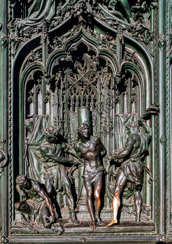 Duomo, portale maggiore: formella in bronzo di L. Pogliaghi, 1894-1908, raffigurante scene della vita di Maria. In questo particolare il soggetto à “Cristo alla colonna”.