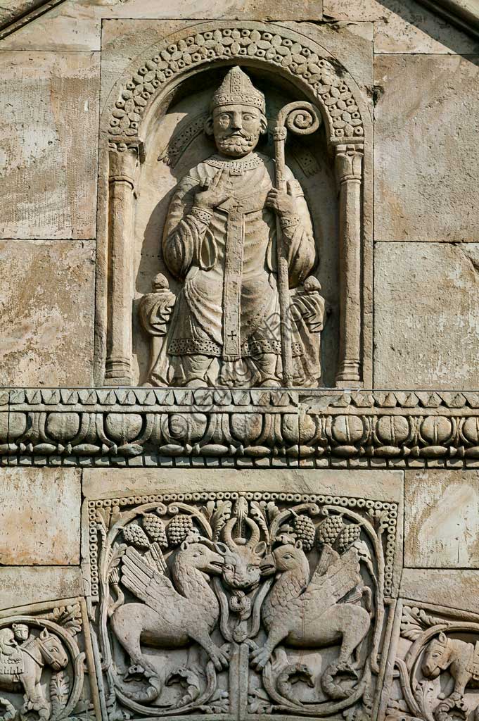 Fidenza, Duomo (Cattedrale di S. Donnino), Facciata,  frontone del portale di destra: l'Arciprete di San Donnino.  Bassorilievo di Benedetto Antelami e bottega.