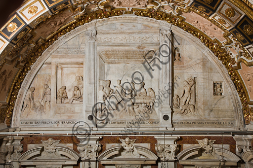 Genoa, Duomo (St. Lawrence Cathedral),the Chapel of St. John the Baptist, Western wall:  lunette with scenes of the life of St. John the Baptist (in the centre, the banquet of Herod and laterally the martyrdom and burial of the Baptist); bas-relief (stiacciato) in marble. The lunette was realised  by Giovanni d’Aria with the collaboration of the brothers Michele and Bonino in 1496.