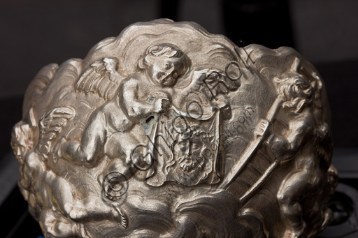   Genoa, Museum of the Treasury of the Cathedral of San Lorenzo: Chalice of the Fathers of Comune; Genoa workshop; second half of XVI century;  embossed, chiseled, gilded silver. The Nativity of Jesus is depicted in the node of the chalice; the Lamentation over the dead Christ is depicted in the base.Detail with angel and portrait of Christ.