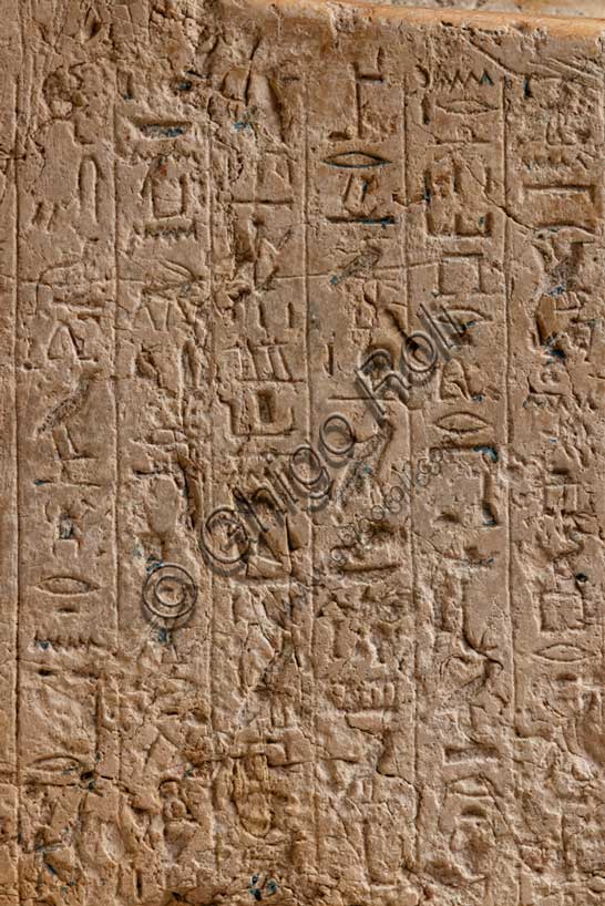 Museo Civico Archeologico di Bologna: statua acefala di Hapuseneb. Hapuseneb fu un funzionario importante alla corte della regina Hatshepsut (1479-1458 a.C.), ricoprendo il ruolo di visir e di primo profeta di Amon; di lui sono noti molti monumenti fra cui un cenotafio a Gebel el Silsila e la tomba a Tebe, da cui proviene probabilmente anche questa statua che lo mostra seduto su un seggio dal basso schienale e con i piedi in appoggio su un alto zoccolo.Particolare con geroglifici.Inventario EG 1822.