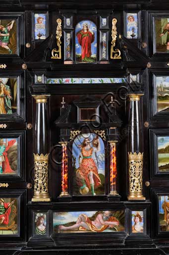 Palermo, The Royal Palace or Palazzo dei Normanni (Palace of the Normans), The Royal Apartment, The Monetiere Room (next to the Chinese Room): the Monetiere, i.e. the wooden cabinet with an ebony veneer, and inlays in tortoise, red lacquers and gilded bronze. Painted glass panels with biblical, mythological and allegorical scenes. Sicilian cabinetmakers, XVII century. Detail with Judith and Holofernes.