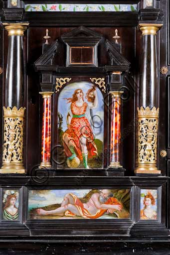 Palermo, The Royal Palace or Palazzo dei Normanni (Palace of the Normans), The Royal Apartment, The Monetiere Room (next to the Chinese Room): the Monetiere, i.e. the wooden cabinet with an ebony veneer, and inlays in tortoise, red lacquers and gilded bronze. Painted glass panels with biblical, mythological and allegorical scenes. Sicilian cabinetmakers, XVII century. Detail with Judith and Holofernes.