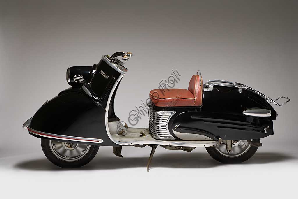 Moto d'epoca Bastert Einspurauto 175. Scooter.Marca: Gustav Bastert Werkemodello: Einspurauto 175nazione: Germania - Bielefeldanno: 1953condizioni: restauratocilindrata: 174,2 (alesaggio e corsa 58 x 66)motore: JLO monocilindrico a due tempicambio: in blocco a quattro rapporti con comando a pedaleMentre in Italia lo scooter si sviluppava e affermava come mezzo economico, leggero e agile, altrove si seguivano altre strade. Questo Einspurauto ("l'auto che lascia una traccia sola") tenta di emulare, almeno esteticamente, l'automobile. Grande, avvolgente, lussuoso e superaccessoriato (aveva persino le frecce laterali a braccetto mobile) costava molto e fu prodotto in appena 1200 esemplari.