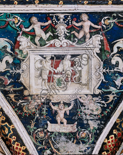 The Piccolomini Library, the vault: spandrel above the south - west wall between  the eighth and the ninth story, frescoes attributed to Girolamo del Pacchia, Giacomo Pacchiarotto and Littifredi Corbizi. The decoration is inspired by the Domus Aurea and the motif of the ancient grotesques. The general scheme of the vault is probably due to Bernardino di Betto, known as Pinturicchio. At the centre grisaille with scene of sacrifice. Detail.