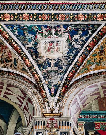 The Piccolomini Library, the vault: spandrel above the south - west wall between  the eighth and the ninth story, frescoes attributed to Girolamo del Pacchia, Giacomo Pacchiarotto and Littifredi Corbizi. The decoration is inspired by the Domus Aurea and the motif of the ancient grotesques. The general scheme of the vault is probably due to Bernardino di Betto, known as Pinturicchio. At the centre grisaille with scene of sacrifice.