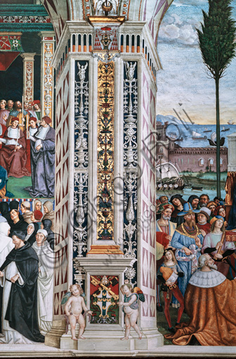 The Piccolomini Library, south-west wall: pilaster between  the ninth scene and the tenth scene of the ten stories about Aeneas Sylvius Piccolomini, future Pope Pius II, (1503 - 1508), frescoes  by Bernardino di Betto, known as Pinturicchio. In the dado, the Piccolomini emblem surmounted by the papal tiara and supported by two putti.