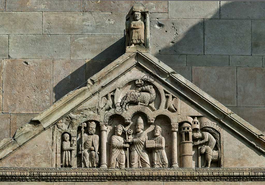 Fidenza, Duomo (St. Donnino Cathedral), Façade, the porch pediment   of the left portal.Frrom left to right: "The emperor Charlemagne, with a warrior on his right";"Pope Adrian II who hands the mitre and the croiser (symbols of episcopal dignity) to the archpriest of San Donnino"; "The miracle of the sick recovered by Domninus of Fidenza". Work by Benedetto Antelami and his workshop.