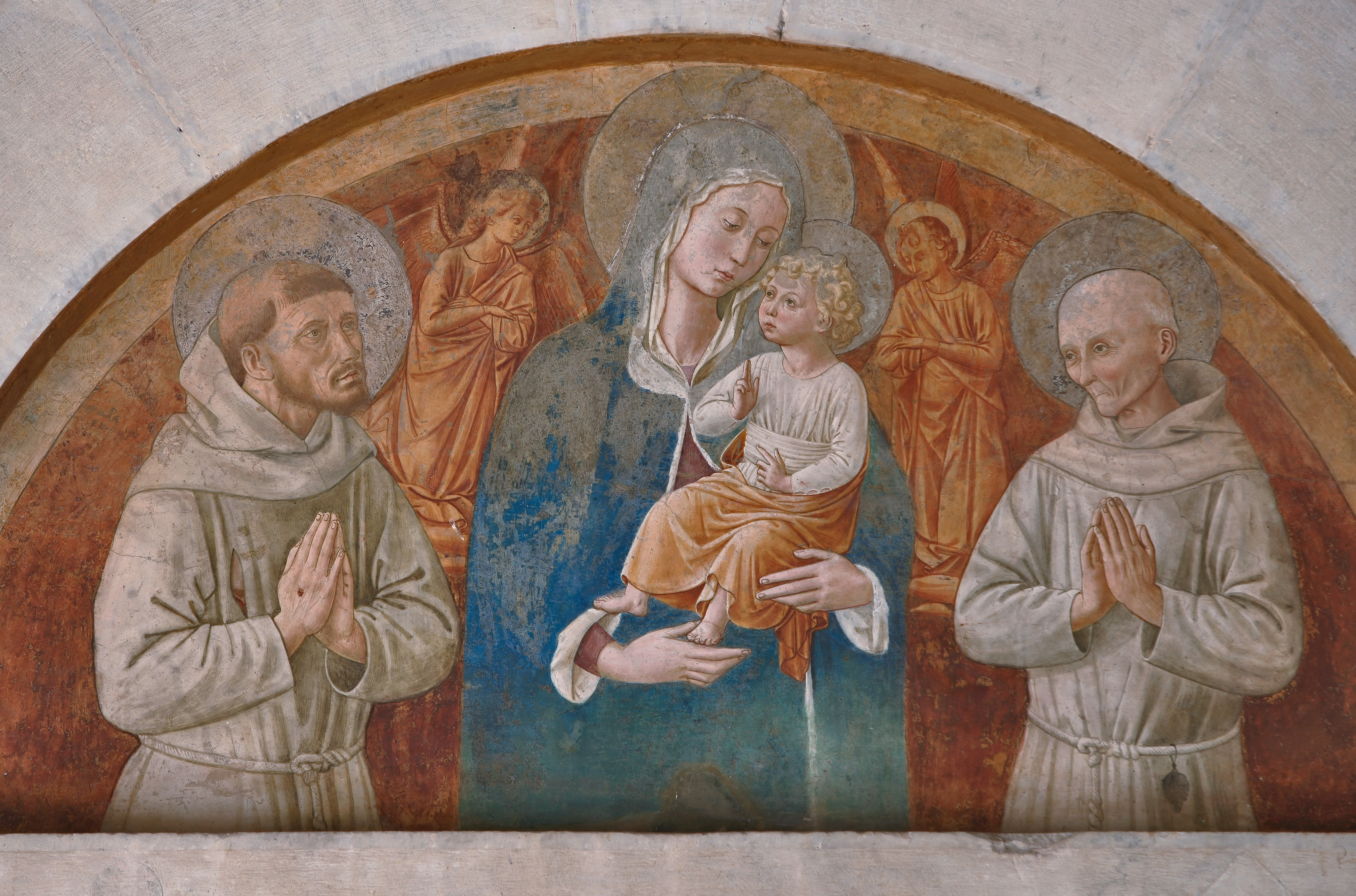 Montefalco, Church of San Fortunato, lunette above the portal: "Madonna and Child with Saints Francis and Bernardino", fresco by Benozzo Gozzoli.