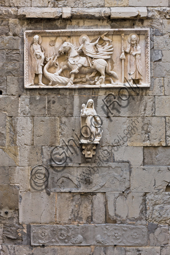 Genova, Duomo (Cattedrale di S. Lorenzo), fianco sud, sezione tra il campanile e il portale di S. Gottardo: "Madonna con Bambino e S. Giovannino che porge dei fiori" (secondo quarto del XVII secolo) e "S. Giorgio e il drago tra S. Giovanni Battista e S. Giacomo maggiore", (sec. XIV), di scultore campionese.