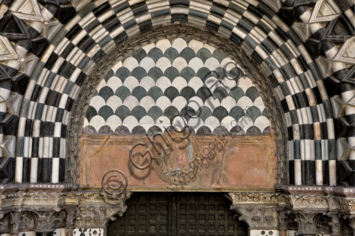 Genova, Duomo (Cattedrale di S. Lorenzo), lato ovest, la facciata, il portale di destra: lunetta e architrave con "Madonna con Bambino tra angeli reggiclipeo" (inizi XVII secolo).