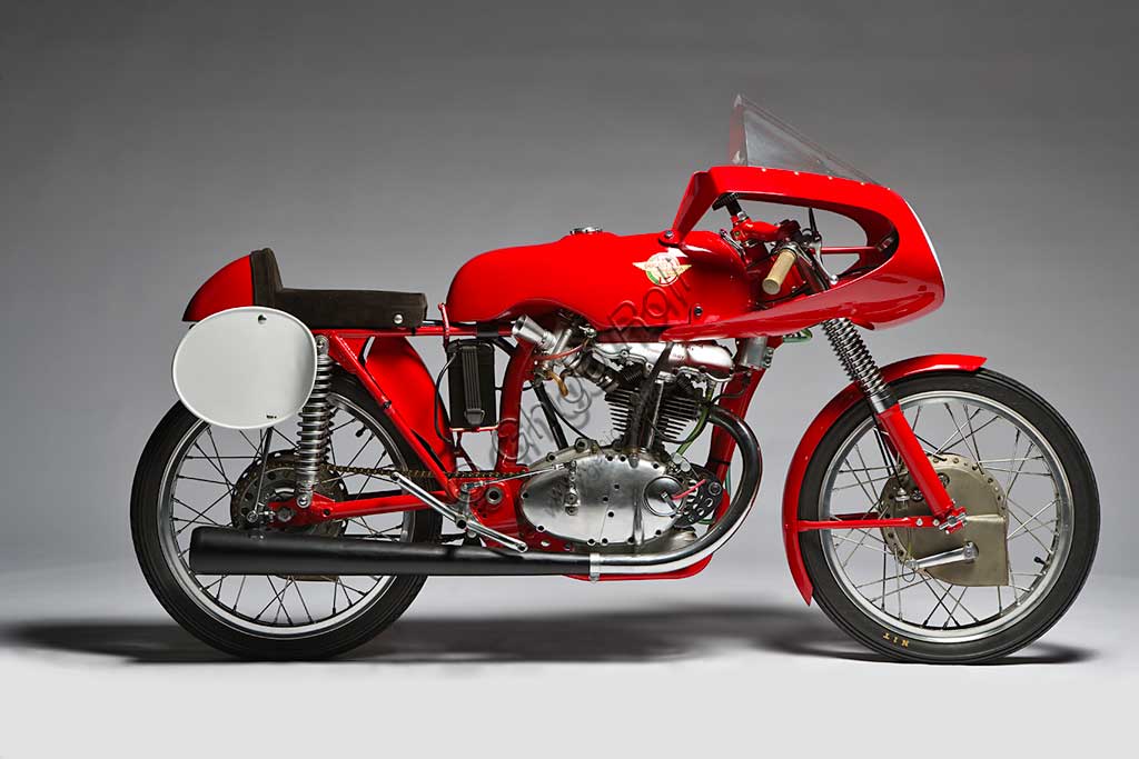 Moto d'epoca Ducati 125 Bialbero Gran PremioMarca: Ducatimodello: 125 Bialbero Gran Premionazione: Italia - Bolognaanno: 1956condizioni: restauratacilindrata: 124,8 (alesaggio e corsa 55,3 x 52)motore: monocilindricocambio: in blocco a cinque rapportiNata nel 1926 a Bologna, inizialmente la Società Scientifica Radio Brevetti Ducati si occupa di tecnologie elettromeccaniche legate alla radio fino al 1946, quando nasce il reparto motociclistico. E' di quell'anno il Cucciolo, ciclomotore a quattro tempi di grande successo. Nel '54 arriva in Ducati Fabio Taglioni, geniale ingegnere imolese che segnerà tutta la produzione Ducati per quasi quarant'anni con le sue soluzioni innovative. E' di quel periodo l'ingresso della Ducati nel mondo delle corse. Questa 125 Bialbero, moto assai rara, è l'erede diretta della 100 Gran Sport, la mitica "Marianna" che regalò le prime importanti vittorie alla Ducati, e precede di pochi mesi la 125  con distribuzione desmodromica, una soluzione che è ancor oggi il segno distintivo della produzione Ducati. 