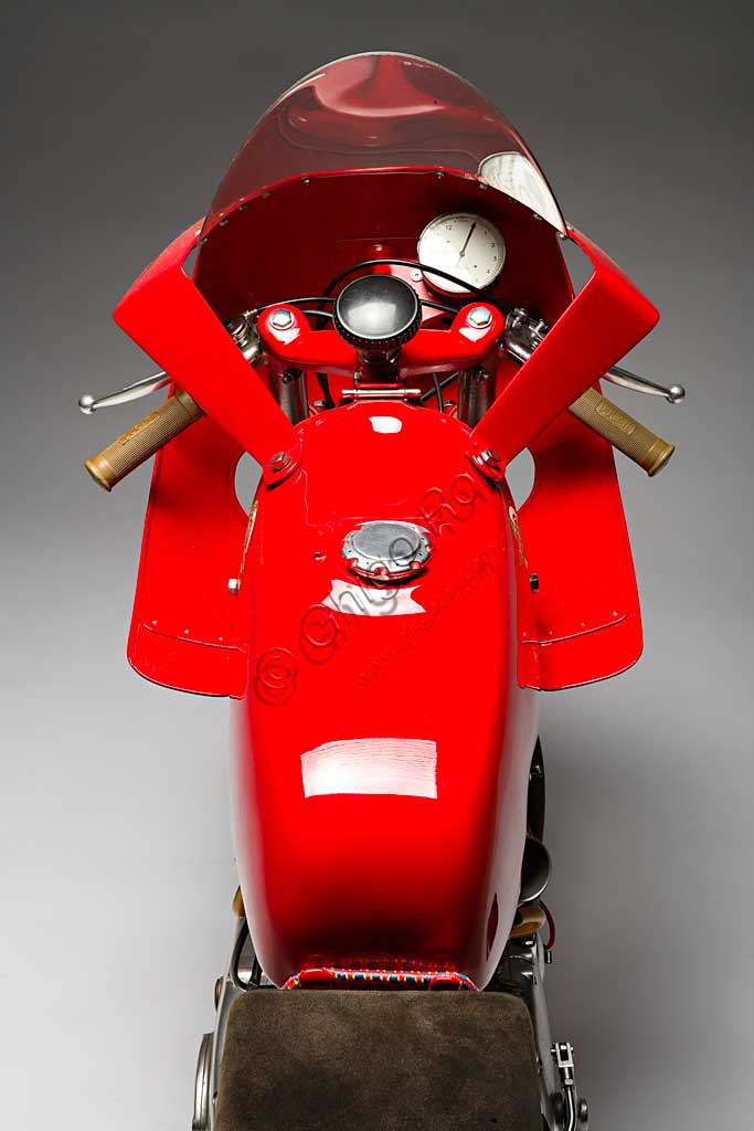 Moto d'epoca Ducati 125 Bialbero Gran PremioMarca: Ducatimodello: 125 Bialbero Gran Premionazione: Italia - Bolognaanno: 1956condizioni: restauratacilindrata: 124,8 (alesaggio e corsa 55,3 x 52)motore: monocilindricocambio: in blocco a cinque rapportiNata nel 1926 a Bologna, inizialmente la Società Scientifica Radio Brevetti Ducati si occupa di tecnologie elettromeccaniche legate alla radio fino al 1946, quando nasce il reparto motociclistico. E' di quell'anno il Cucciolo, ciclomotore a quattro tempi di grande successo. Nel '54 arriva in Ducati Fabio Taglioni, geniale ingegnere imolese che segnerà tutta la produzione Ducati per quasi quarant'anni con le sue soluzioni innovative. E' di quel periodo l'ingresso della Ducati nel mondo delle corse. Questa 125 Bialbero, moto assai rara, è l'erede diretta della 100 Gran Sport, la mitica "Marianna" che regalò le prime importanti vittorie alla Ducati, e precede di pochi mesi la 125  con distribuzione desmodromica, una soluzione che è ancor oggi il segno distintivo della produzione Ducati. 