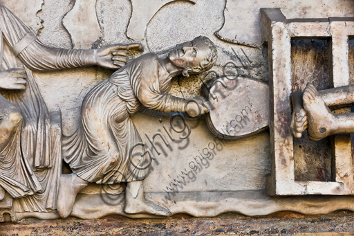 , Genoa, Duomo (St. Lawrence Cathedral), West side, the façade, the main doorway: detail of the lunette with "The Martyrdom of St. Lawrence", by Master of lunette of the Genoa Cathedral, 1225.Detail of a tormenter holding the bellows.