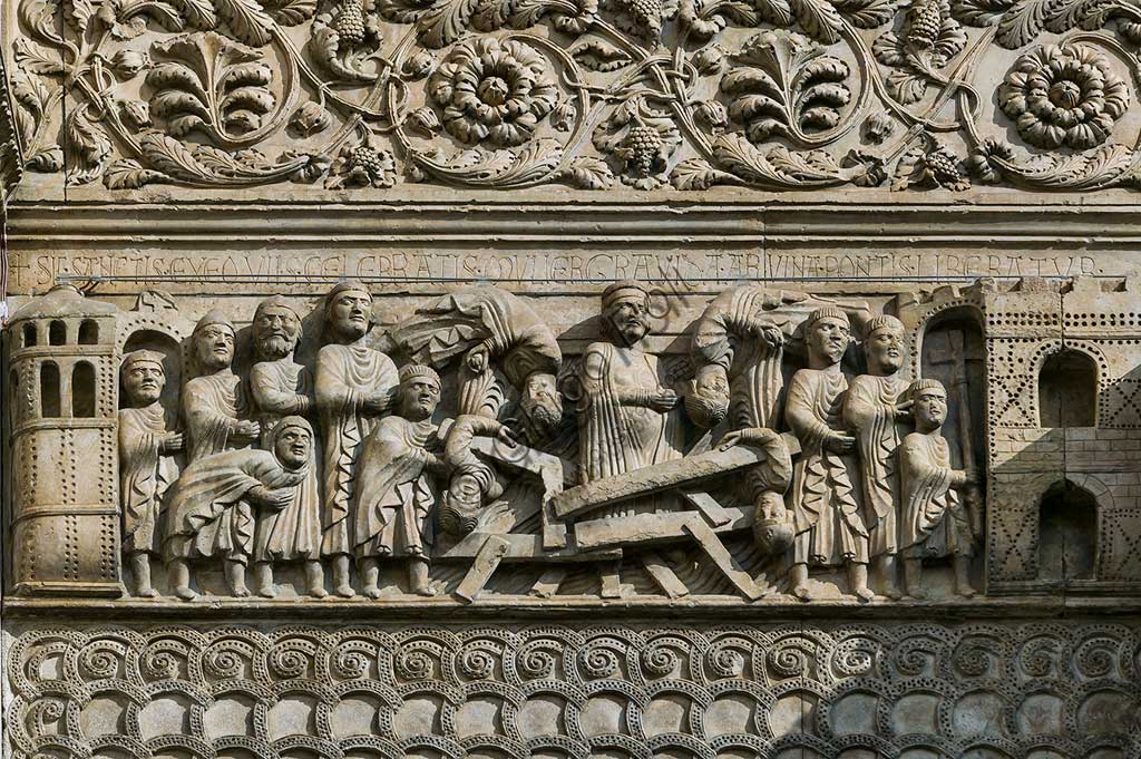 Fidenza, Duomo (Cattedrale di S. Donnino), Facciata: bassorilievo con Storie di San Donnino, "Il miracolo della donna gravida", che racconta con drammaticità l'episodio del crollo di un ponte eccessivamente affollato e il salvataggio della donna incinta per intervento del Santo. Benedetto Antelami e bottega.