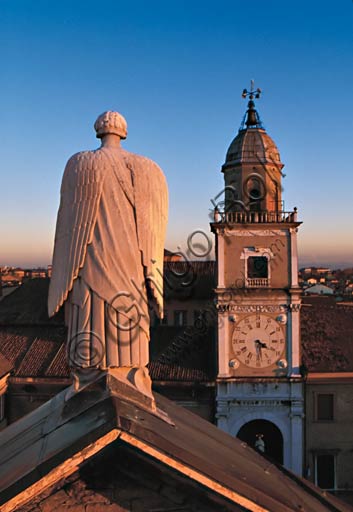 Modena: statue of Archangel Gabriele on the tympanum of the central transept of the Cathedral. In the backgroundd, the Civic Tower.