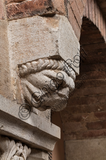 Modena, Ghirlandina Tower, Torresani Hall, east wall: a Corinthian capital with a sculpted face in the abacus protome. Campionese Masters, XII - XIII century. Detail.