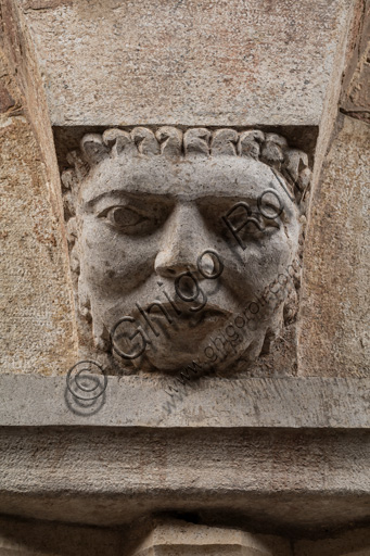 Modena, Ghirlandina Tower, Torresani Hall, north wall: a Corinthian capital with a sculpted face in the abacus protome. Campionese Masters, XII - XIII century. Detail.