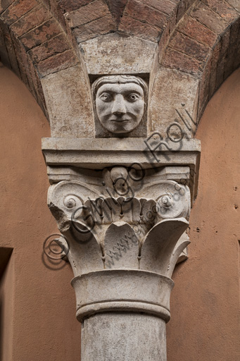 Modena, Ghirlandina Tower, Torresani Hall, north wall: a Corinthian capital with a sculpted face in the abacus protome. Campionese Masters, XII - XIII century.