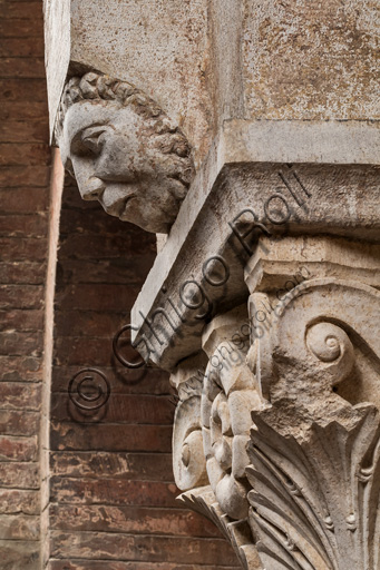 Modena, Ghirlandina Tower, Torresani Hall, north wall: a Corinthian capital with a sculpted face in the abacus protome. Campionese Masters, XII - XIII century.