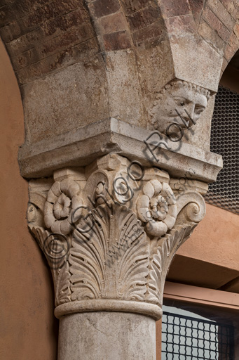 Modena, Ghirlandina Tower, Torresani Hall, north wall: a Corinthian capital with a sculpted face in the abacus protome. Campionese Masters, XII - XIII century.